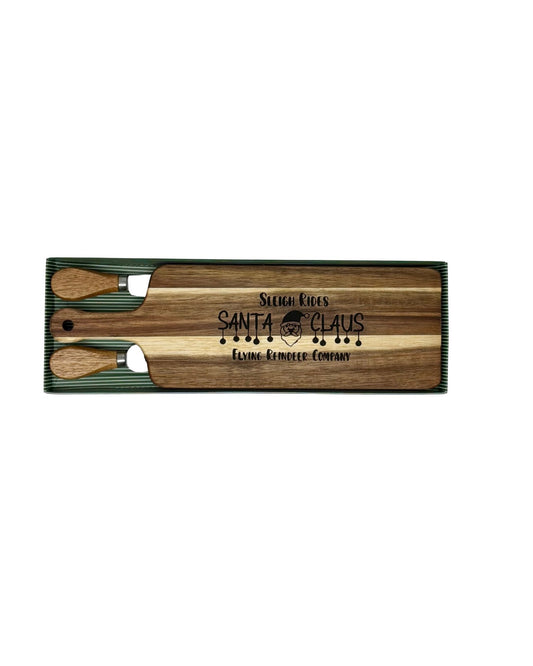 Sleigh Rides Santa Claus cheese board with wood-handled cheese fork and spreader in a green striped gift box